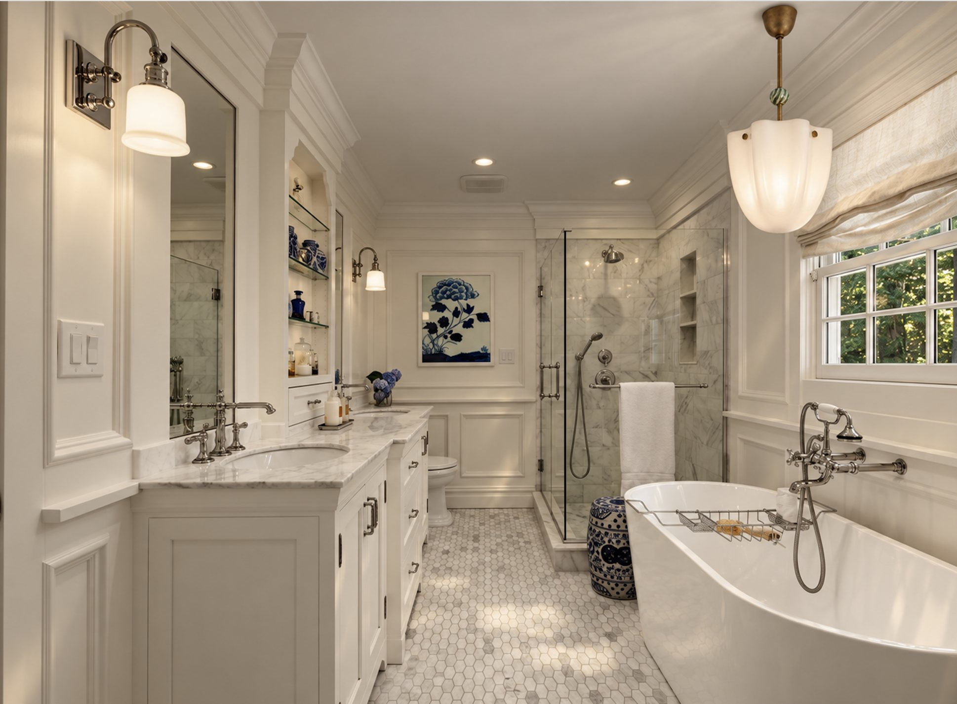 White paneled bath with a freestanding tub, marble vanity and glass shower
