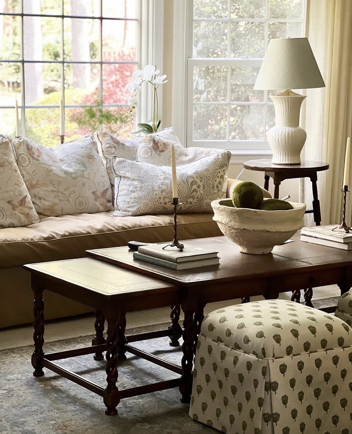 Sofa layered with floral pillows beside a carved coffee table, Muttontown
